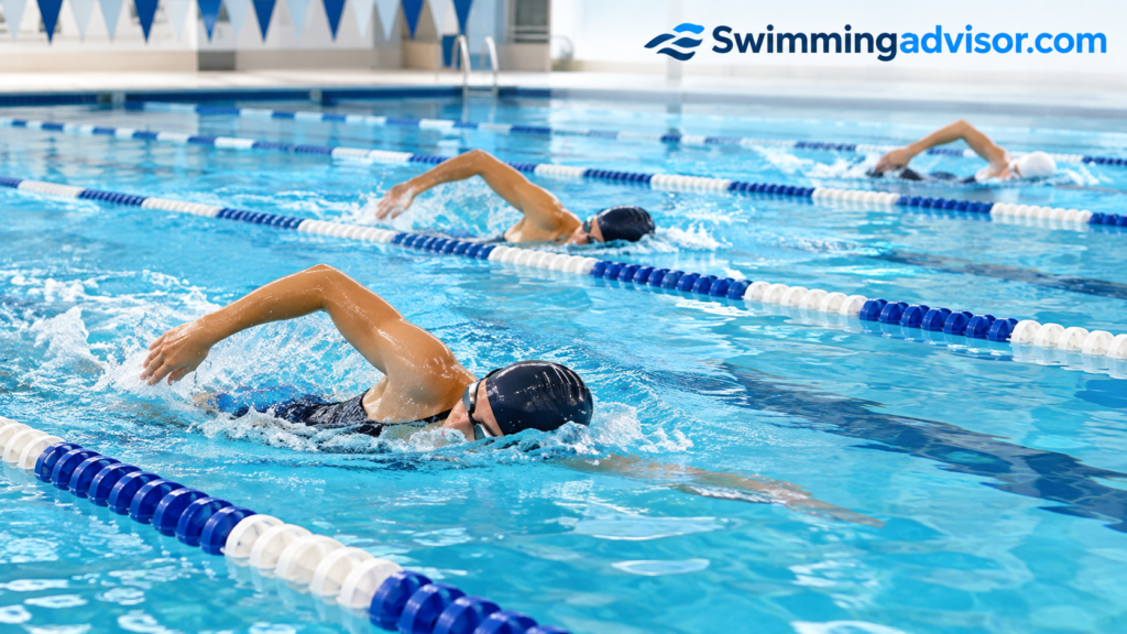 Lane swimmers moving steadily through a pool in a calm aerobic training set